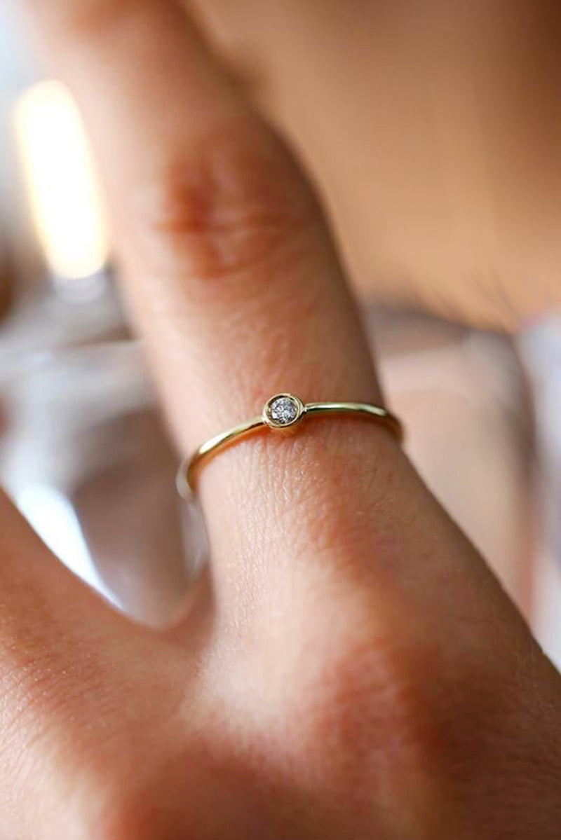 A dainty ring with a minimalist concept that adds a glittering edge to your outfit. Believe us, it will never go out of style. The classic round design of this 14K solid gold ring embraces a delicate and posh finished. Details: Made in 14K Solid Yellow Gold With White Cubic Zirconia Size 5.6.7.8 Hypoallergenic Fine Jewelry. miramira New York