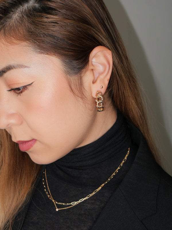 With a cross twist of minimalism, this beautiful pair of earrings is one of the eras. A classic yet fabulous accessory made for everyday comfort and style. The piece you are looking to add to your collection. You can wear it alone or with the Chelsea gold twist ring to elevate your look.  Details:  18K Gold Plated Recycle Brass  Length 2.5cm - Width 0.6cm  Weight about 10g/pair  Hypoallergenic