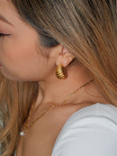 Add an effortless Parisian charm to your look with the Chunky Croissant Gold Hoops. These statement earrings are crafted from 18k gold plated metal, making them strong and durable without compromising on style. Let your inner fashionista shine!  Details:  18K Gold Plated on Stainless Steel  Made in Stainless Steel  Length 2.5cm - Width 2.5cm  Diameter Width 20mm  Weight about 17g/pair  Hypoallergenic