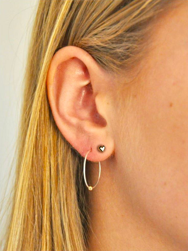 A heart shaped in a stud. This pair of earrings will make your style sweet and timeless. The puffed polished feature creates a brilliant luster for a unique layered look. Love will whisper in your ear whenever you wear this cute and minimal piece.  Details:  Made in 14K Solid Yellow Gold  Dimensions: 5mm  Hypoallergenic   Fine Jewelry. miramira New York