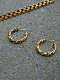 City-cool style, the perfect pair of gold hoop earrings to do glam in a modern-sleek way. Believe us - you will want to wear it with everything. Made in 18K Gold-Filled. Your go-to piece for date night or a boozy brunch.   Details:  18K Gold Filled   Made in Gold Filled  Length cm - Width cm  Diameter Width mm  Weight about g/pair  Hypoallergenic 