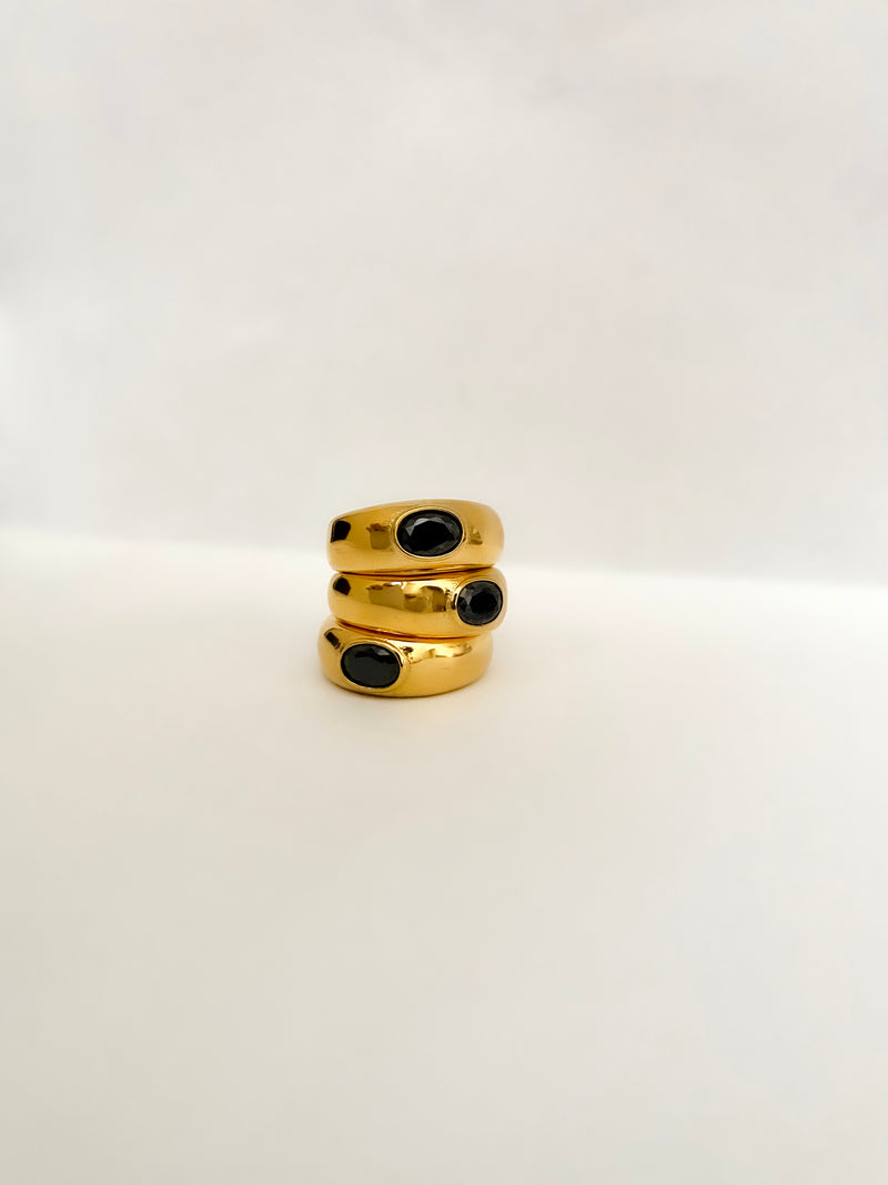 The perfect stainless steel ring accessory to impress those around you while running errands or on a date night. A delicate oval black stone centerpiece. A vintage and unisex design meant to be worn by all.    Details:  18K Gold Plated in Stainless Steel  Made in Stainless Steel  Black Gemstone  Available in US ring sizes 6, 7, and 8.  Weight about 7 g  Surface Width 4.5 mm